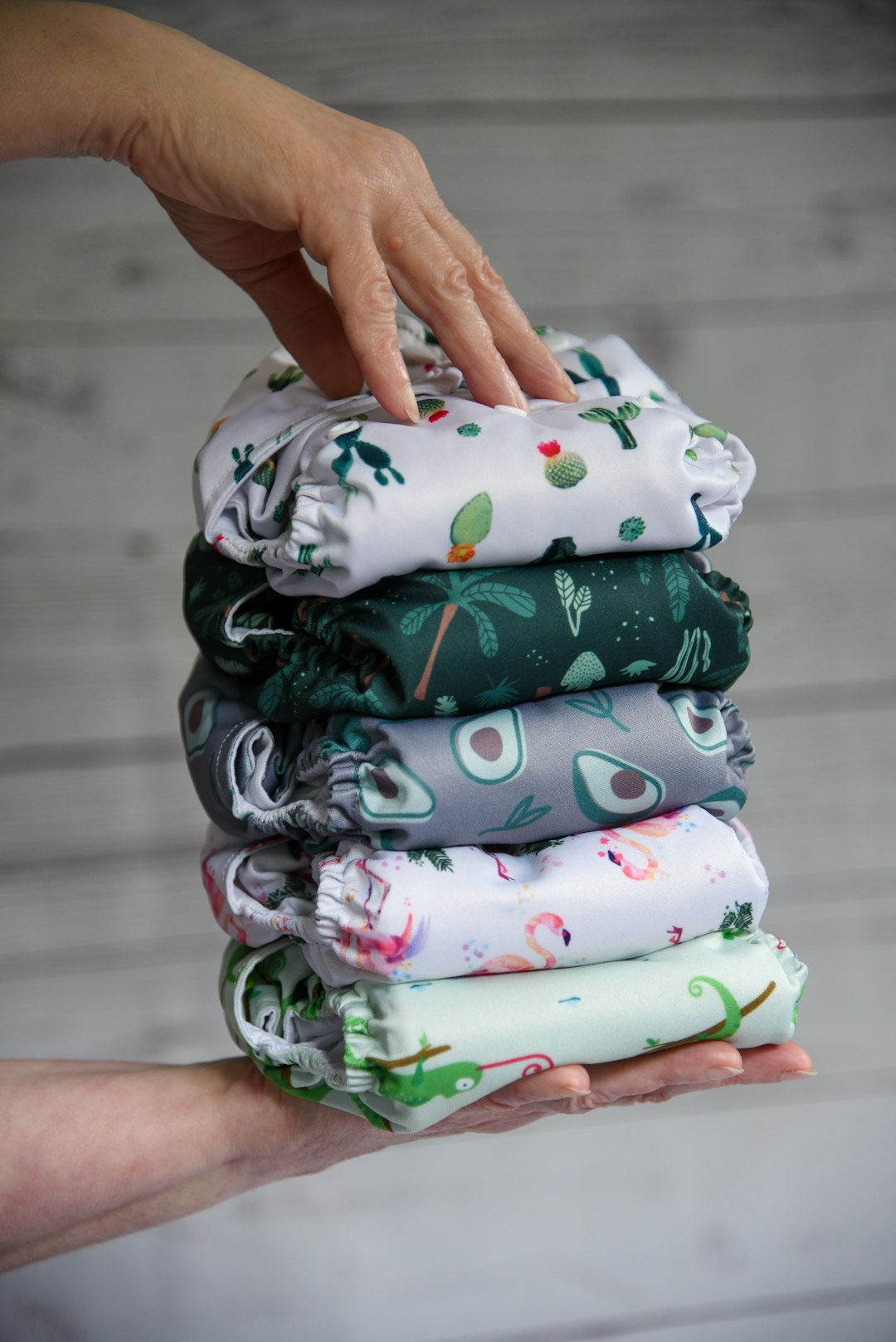 a person holding a stack of folded cloths